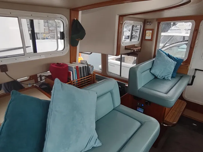 Salish Nomad Yacht Photos Pics Interior of 2007 American Tug 34 with teal seating and nautical decor.
