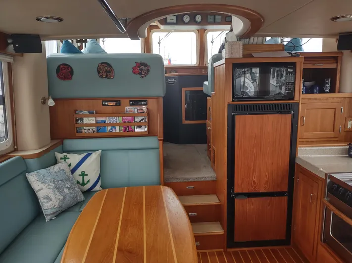 Salish Nomad Yacht Photos Pics Interior of 2007 American Tug 34 with wood finishes and cozy seating area.