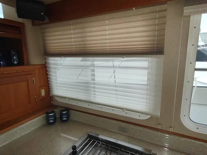 Salish Nomad Yacht Photos Pics Interior of 2007 American Tug 34 with window blinds and wooden cabinetry.