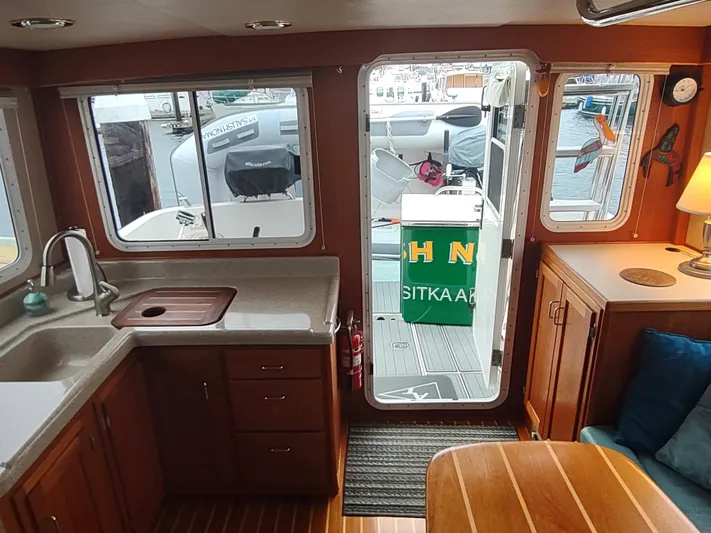 Salish Nomad Yacht Photos Pics Interior of 2007 American Tug 34 with kitchen and outdoor view.