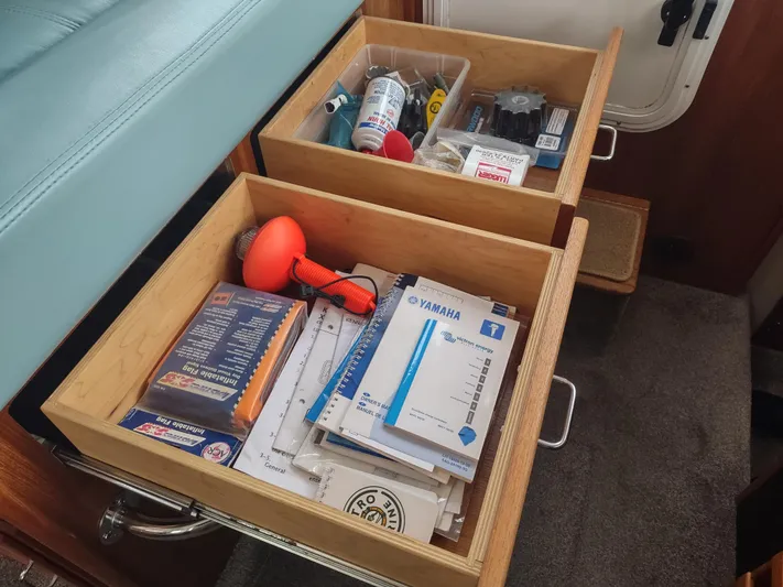 Salish Nomad Yacht Photos Pics Open drawers in 2007 American Tug 34, containing manuals, tools, and supplies.