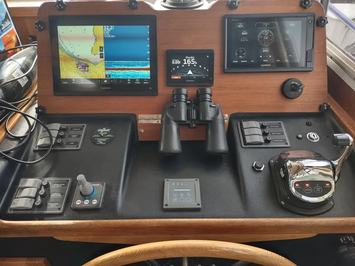 Salish Nomad Yacht Photos Pics Control panel of a 2007 American Tug 34 with navigation screens and controls.