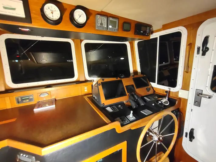 Salish Nomad Yacht Photos Pics 2007 American Tug 34 helm with navigation instruments and wooden steering wheel.