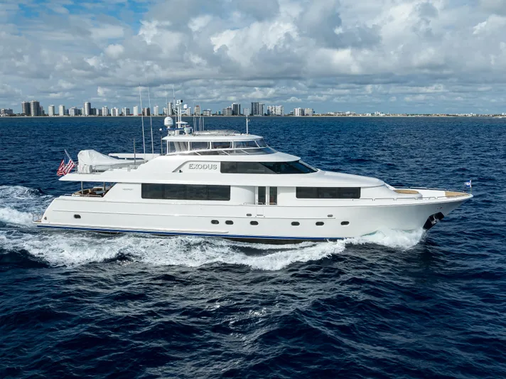 Exodus Yacht Photos Pics Luxury 2008 Westport 112 yacht cruising on open sea with city skyline backdrop.
