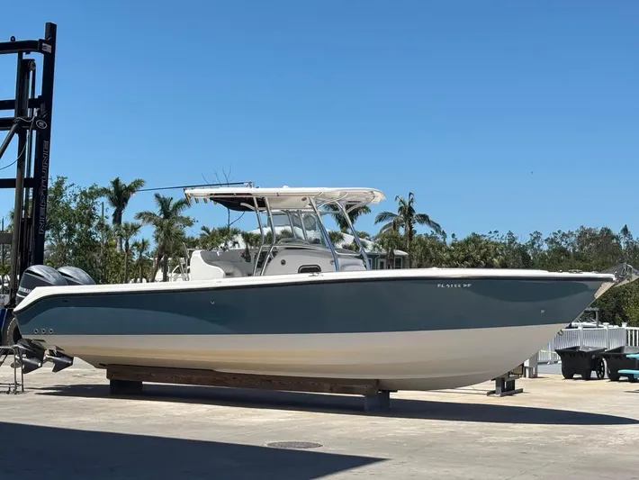 Yacht Photos Pics 2012 Edgewater 318CC boat on display, blue and white hull, sunny day, palm trees in background.