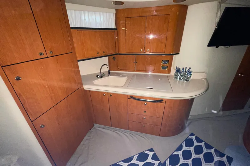  Yacht Photos Pics 2001 Sea Ray Sundancer 460 yacht kitchen with wooden cabinets and modern sink.