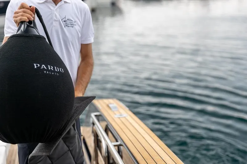 Sirocco Yacht Photos Pics Man holding Pardo Yachts fender on a 2021 Pardo 43 yacht deck.