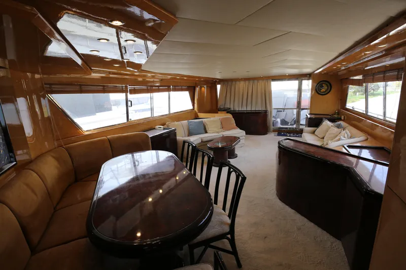  Yacht Photos Pics Luxurious interior of a 1990 Sanlorenzo 80 yacht with elegant wood finishes and plush seating.