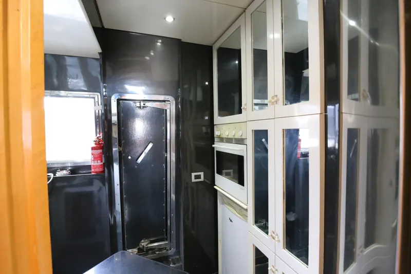  Yacht Photos Pics Interior of 1990 Sanlorenzo 80 yacht kitchen with modern appliances and sleek cabinetry.