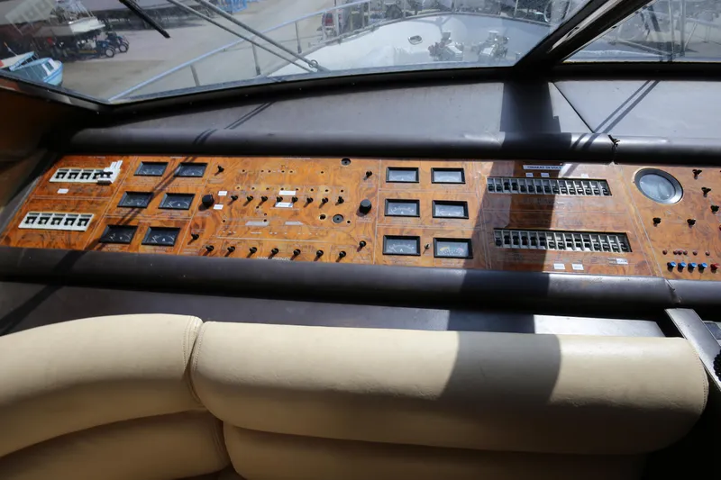  Yacht Photos Pics Control panel of a 1990 Sanlorenzo 80 yacht with wood finish and various instruments.
