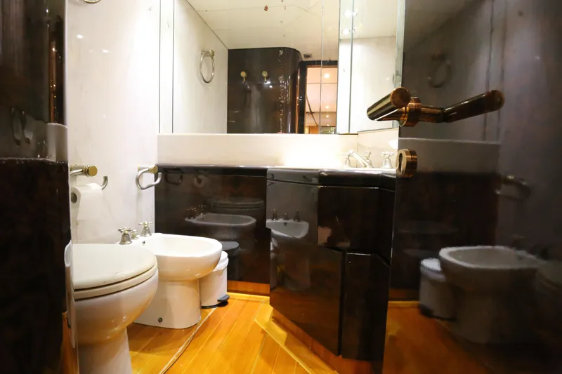  Yacht Photos Pics Luxurious bathroom in 1990 Sanlorenzo 80 yacht with modern fixtures and wooden flooring.