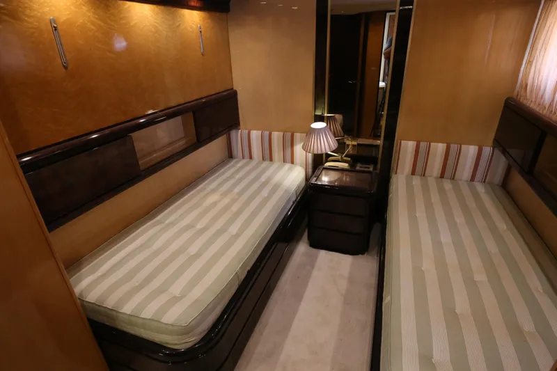  Yacht Photos Pics Twin cabin interior of 1990 Sanlorenzo 80 yacht with striped bedding and warm lighting.