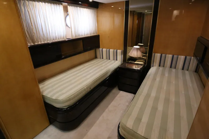  Yacht Photos Pics Twin cabin interior of 1990 Sanlorenzo 80 yacht with striped bedding and wooden finishes.