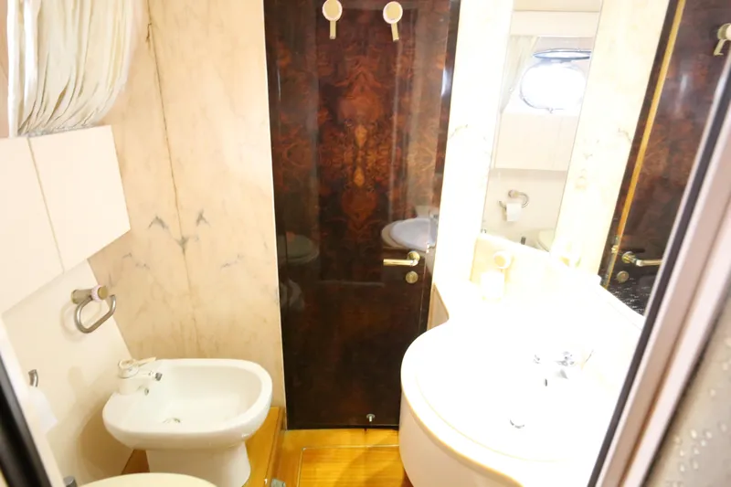  Yacht Photos Pics Bathroom interior of a 1990 Sanlorenzo 80 yacht, featuring a bidet and sink.