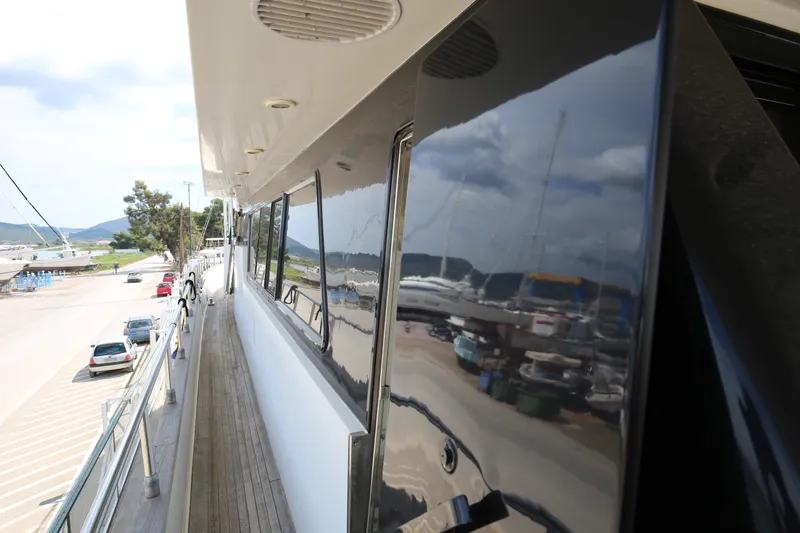  Yacht Photos Pics Sanlorenzo 80 yacht deck view, 1990 model, reflecting marina and parked cars.