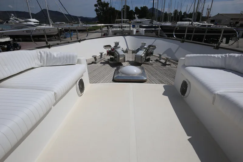  Yacht Photos Pics Bow view of 1990 Sanlorenzo 80 yacht with white seating and deck equipment.