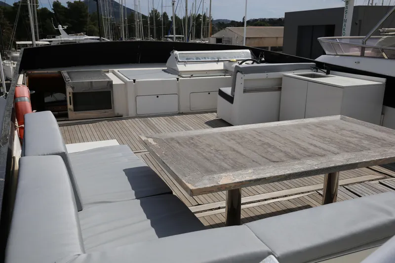  Yacht Photos Pics Spacious deck of 1990 Sanlorenzo 80 yacht with seating and dining area.