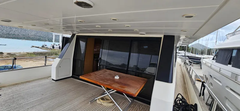  Yacht Photos Pics Sanlorenzo 80 yacht deck with wooden table, docked at marina, 1990 model.