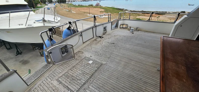  Yacht Photos Pics Deck of a 1990 Sanlorenzo 80 yacht with ocean view and docked boat nearby.