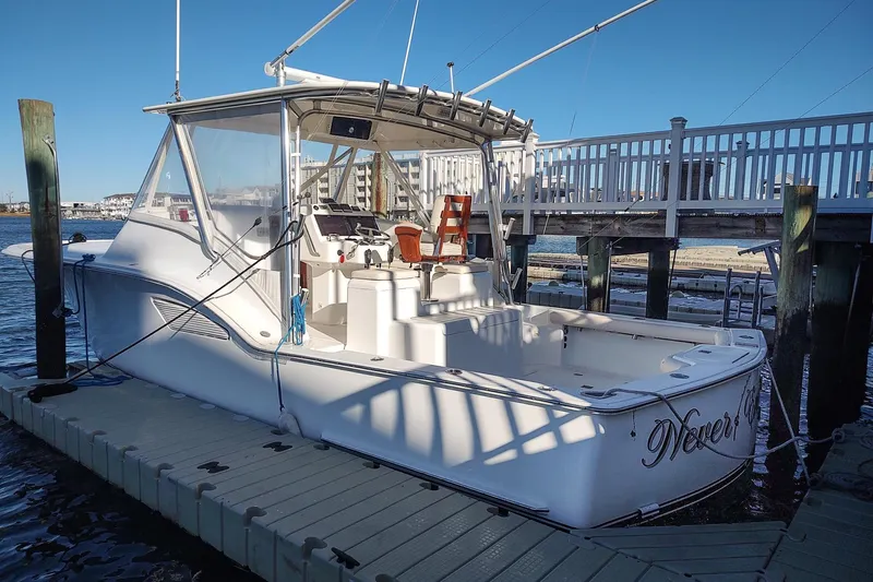 Never Enough Yacht Photos Pics 2017 Out Island SeaTek 36 Express boat docked at marina, clear sky background.