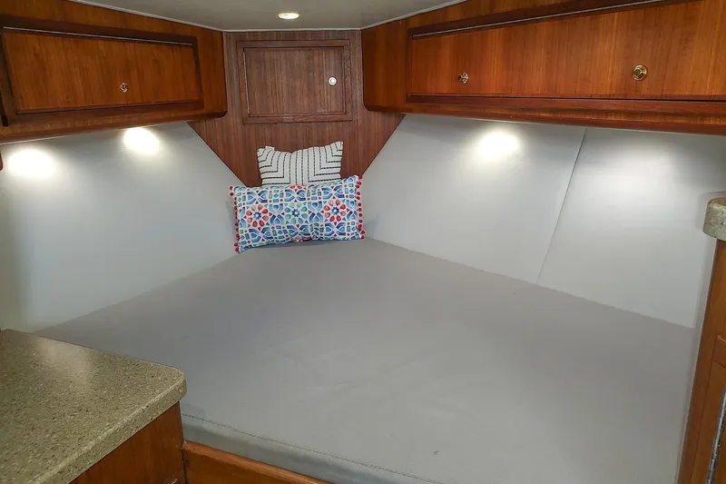 Never Enough Yacht Photos Pics 2017 Out Island SeaTek 36 Express cabin interior with cozy bed and wooden cabinets.