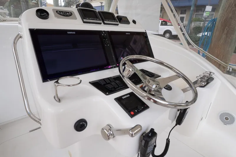 Never Enough Yacht Photos Pics Helm of 2017 Out Island SeaTek 36 Express with dual Simrad displays and stainless steel steering wheel.