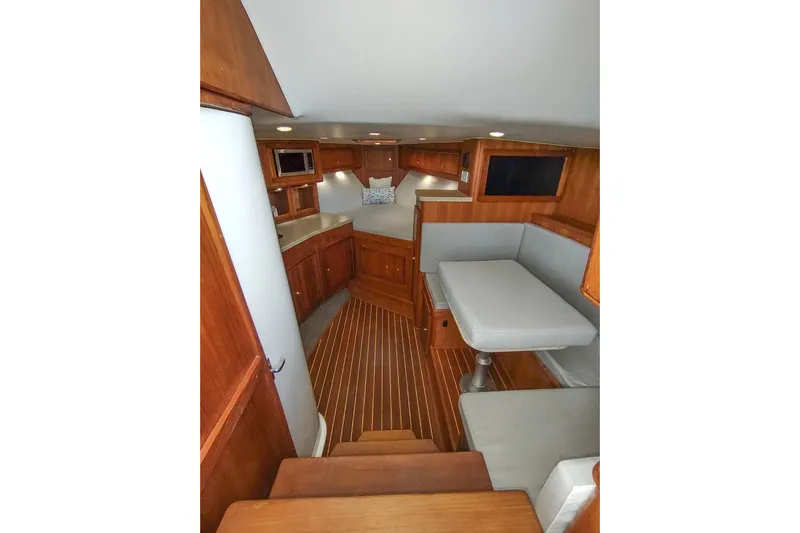 Never Enough Yacht Photos Pics 2017 Out Island SeaTek 36 Express cabin interior with wood finish and seating area.