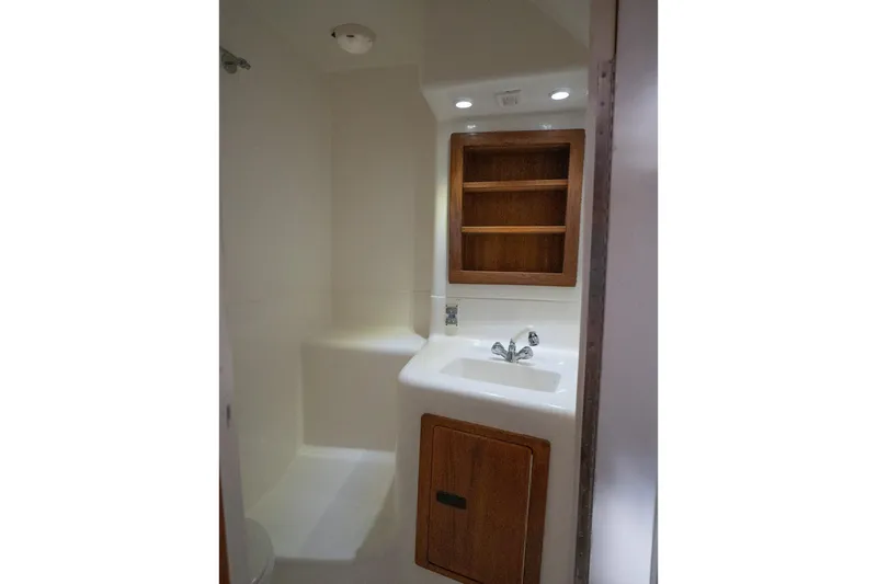 Never Enough Yacht Photos Pics 2017 Out Island SeaTek 36 Express bathroom with sink, wooden cabinet, and modern fixtures.