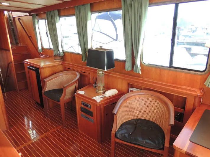 Nighthawk Yacht Photos Pics Luxurious 1999 Lyman-Morse pilothouse interior with wooden furnishings and elegant seating.