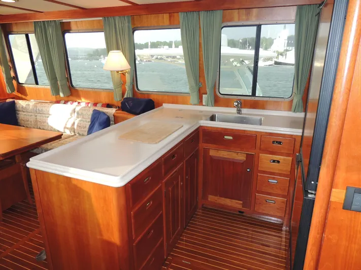 Nighthawk Yacht Photos Pics Interior of 1999 Lyman-Morse pilothouse with wooden cabinetry and large windows.