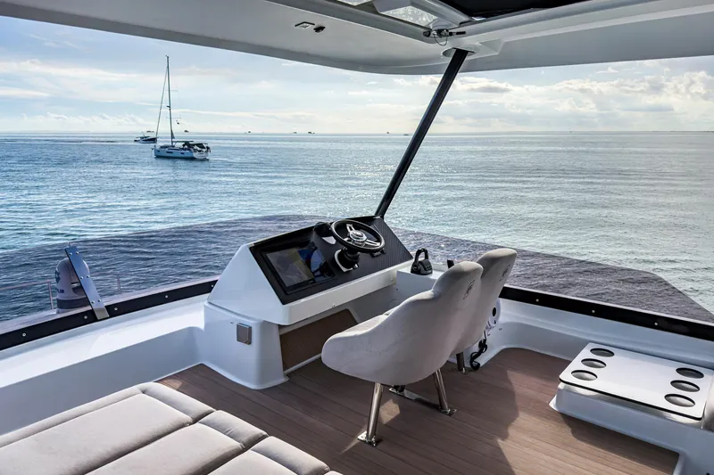 Hawkeye Yacht Photos Pics 2022 Fountaine Pajot MY6 yacht helm with ocean view and distant sailboats.