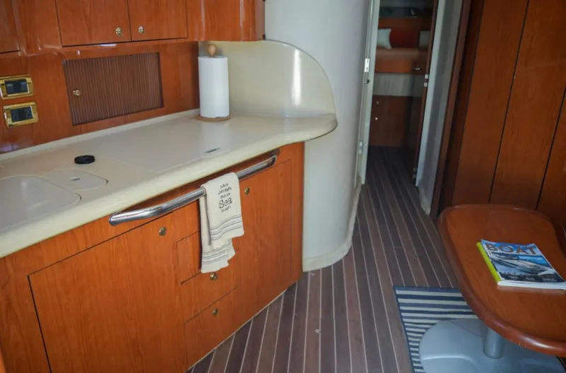  Yacht Photos Pics 2001 Sea Ray Express Cruiser interior with kitchenette, wooden cabinetry, and striped flooring.