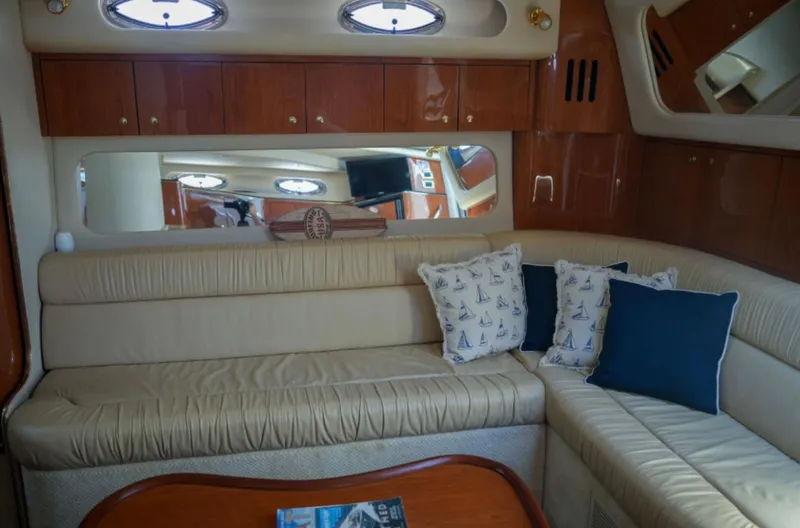  Yacht Photos Pics Interior of 2001 Sea Ray Express Cruiser with beige seating and nautical-themed pillows.