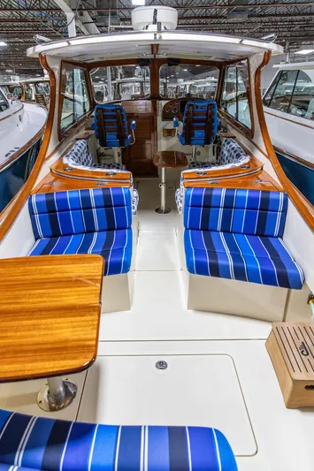 Valor Yacht Photos Pics 2014 Hinckley Talaria 34 interior with blue striped seating and wooden accents.