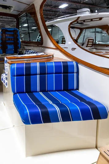 Valor Yacht Photos Pics 2014 Hinckley Talaria 34 interior with blue striped seating and elegant wood accents.