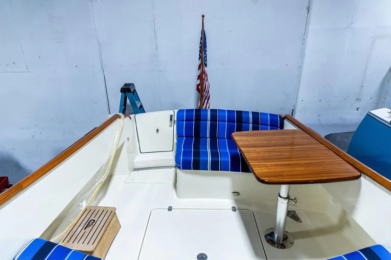 Valor Yacht Photos Pics 2014 Hinckley Talaria 34 boat interior with blue-striped seating and wooden table.