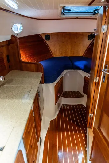 Valor Yacht Photos Pics Interior of 2014 Hinckley Talaria 34 yacht with wooden finish and blue seating.
