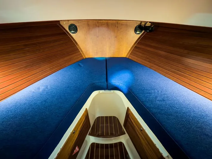 Valor Yacht Photos Pics Interior cabin of 2014 Hinckley Talaria 34 with blue upholstery and wooden accents.