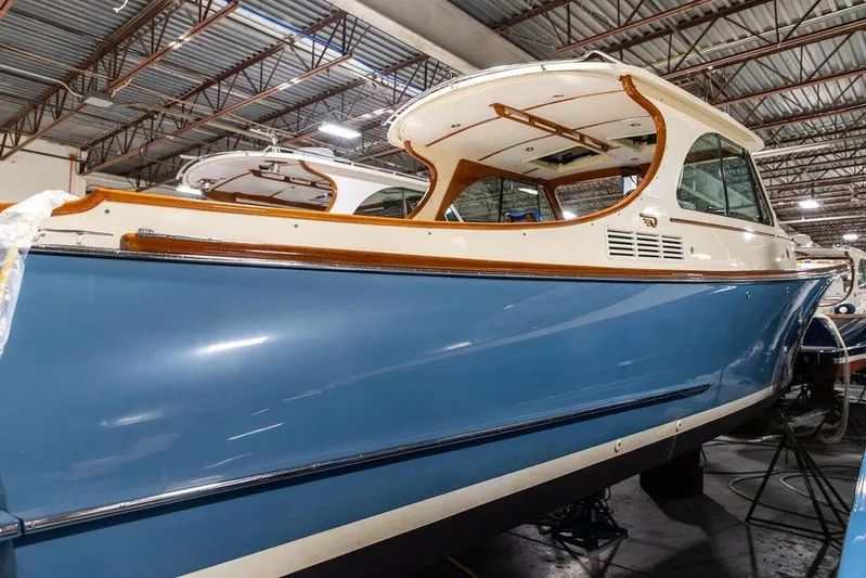 Valor Yacht Photos Pics 2014 Hinckley Talaria 34 boat in a warehouse, showcasing sleek blue hull design.