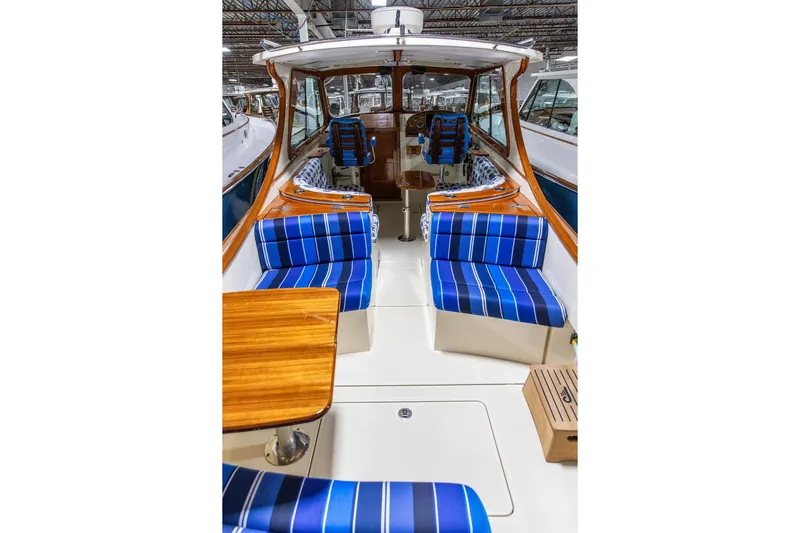 Valor Yacht Photos Pics 2014 Hinckley Talaria 34 interior with blue-striped seating and wooden accents.