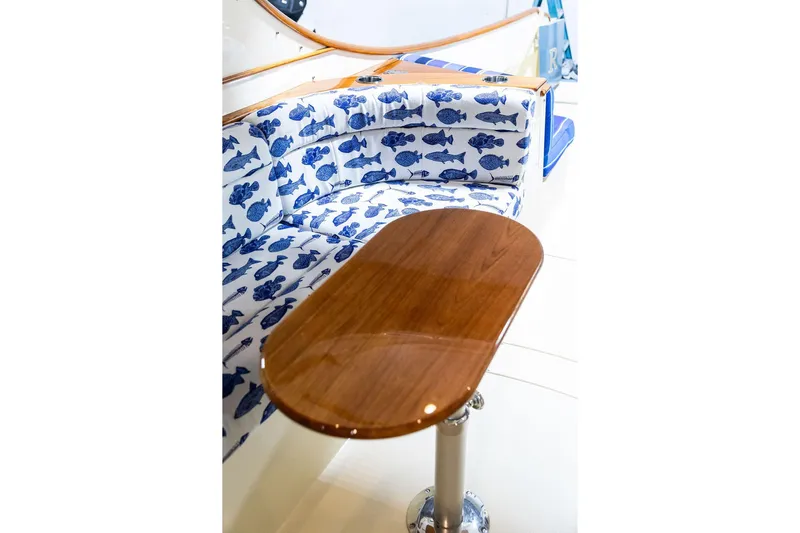 Valor Yacht Photos Pics Luxurious 2014 Hinckley Talaria 34 yacht interior with fish-patterned seating and polished wooden table.