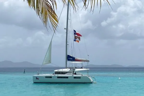 Lone Star Lagoon Yacht Photos Pics 2019 Lagoon 50 catamaran sailing in turquoise waters under cloudy skies.