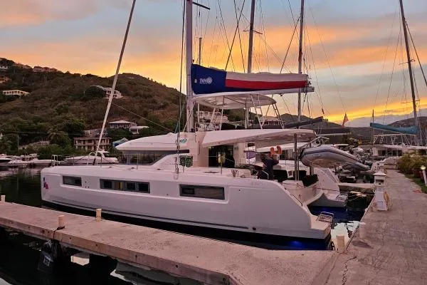 Lone Star Lagoon Yacht Photos Pics 2019 Lagoon 50 catamaran docked at sunset, showcasing sleek design and spacious deck.
