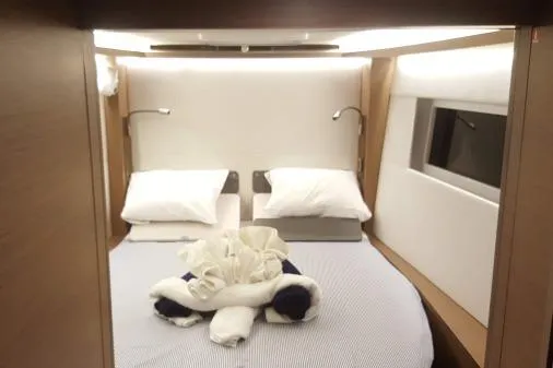 Lone Star Lagoon Yacht Photos Pics Luxurious cabin interior of 2019 Lagoon 50 yacht with elegant bedding and modern lighting.