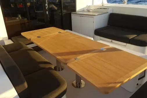 Lone Star Lagoon Yacht Photos Pics Spacious seating area on 2019 Lagoon 50 yacht with wooden table and cushioned benches.