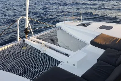 Lone Star Lagoon Yacht Photos Pics 2019 Lagoon 50 catamaran deck with netting and seating, sailing on open water.