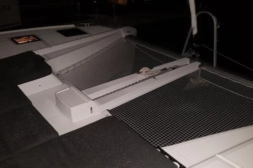 Lone Star Lagoon Yacht Photos Pics 2019 Lagoon 50 catamaran deck with netting and seating area at night.