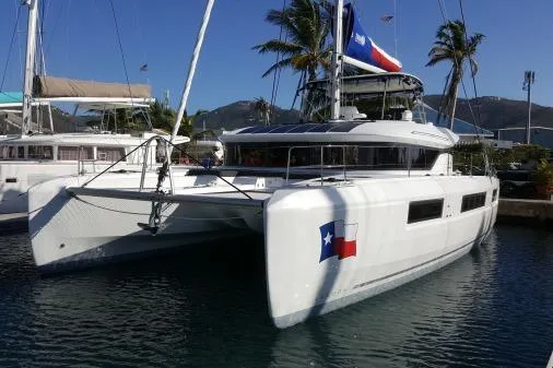 Lone Star Lagoon Yacht Photos Pics 2019 Lagoon 50 catamaran docked, featuring sleek design and Texas flag emblem.