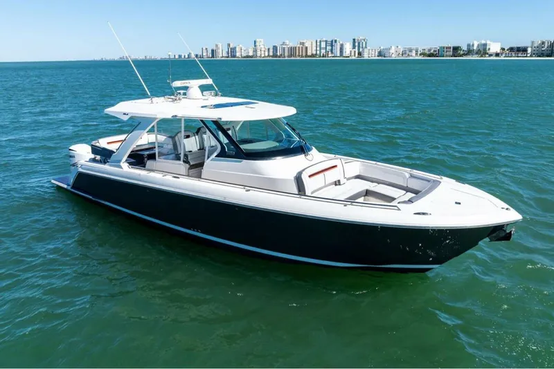 Luna B Yacht Photos Pics 2018 Tiara Yachts 38 LS cruising on calm blue waters near a city skyline.