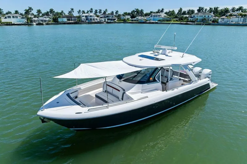 Luna B Yacht Photos Pics 2018 Tiara Yachts 38 LS boat on calm water, featuring a sleek design and sunshade.